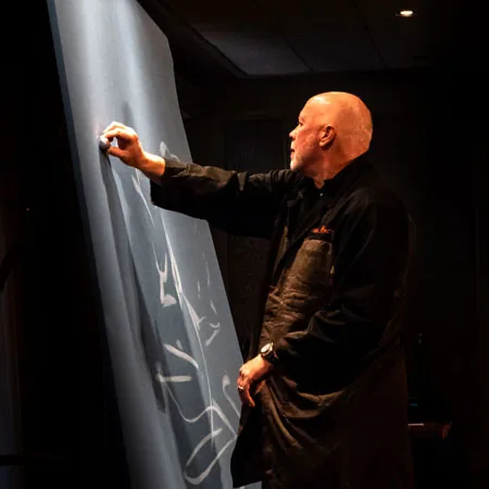 Richard Hight drawing live on a large canvas on stage